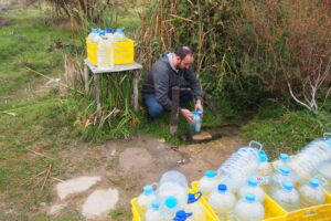 Martin Konev from the Miss Stone Center fills bottles with drinking water